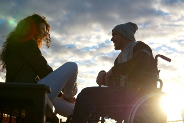 Two people in wheelchairs talking